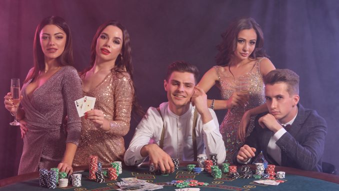 Friends playing poker at casino, at table with stacks of chips, money, cards on it. Celebrating win, smiling. Black, smoke background. Close-up. Laziobet X ( Twitter ) Hesabı
